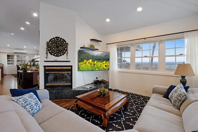a living room with furniture a flat screen tv and a fireplace