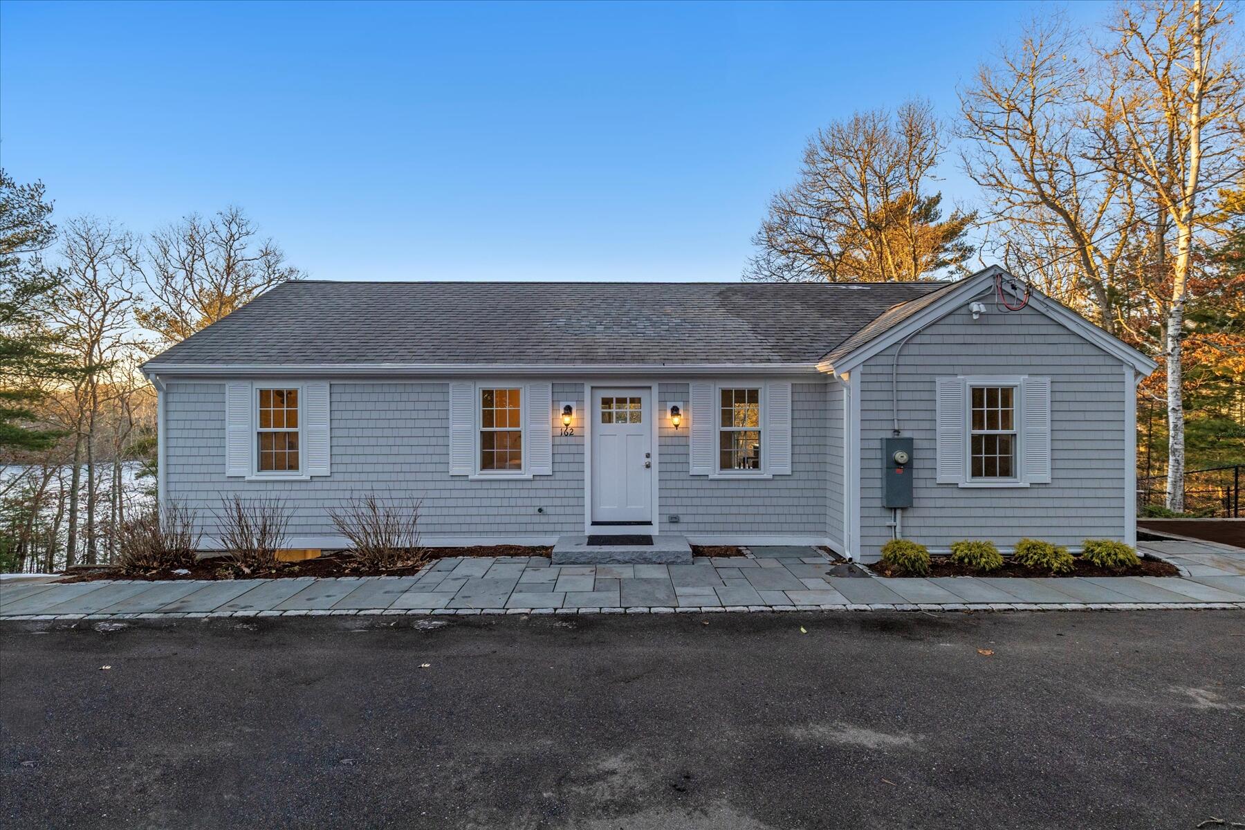 162 Main Street Osterville, MA 02655 - Photo 40 of 47 a front view of house with yard and trees in the background