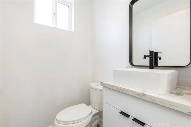 a bathroom with a sink a toilet and mirror