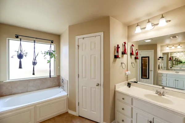 a bathroom with a tub a sink and a window