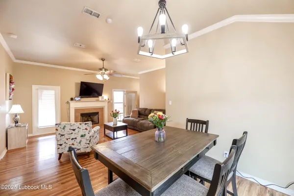 a view of a dining room with furniture a chandelier and wooden floor