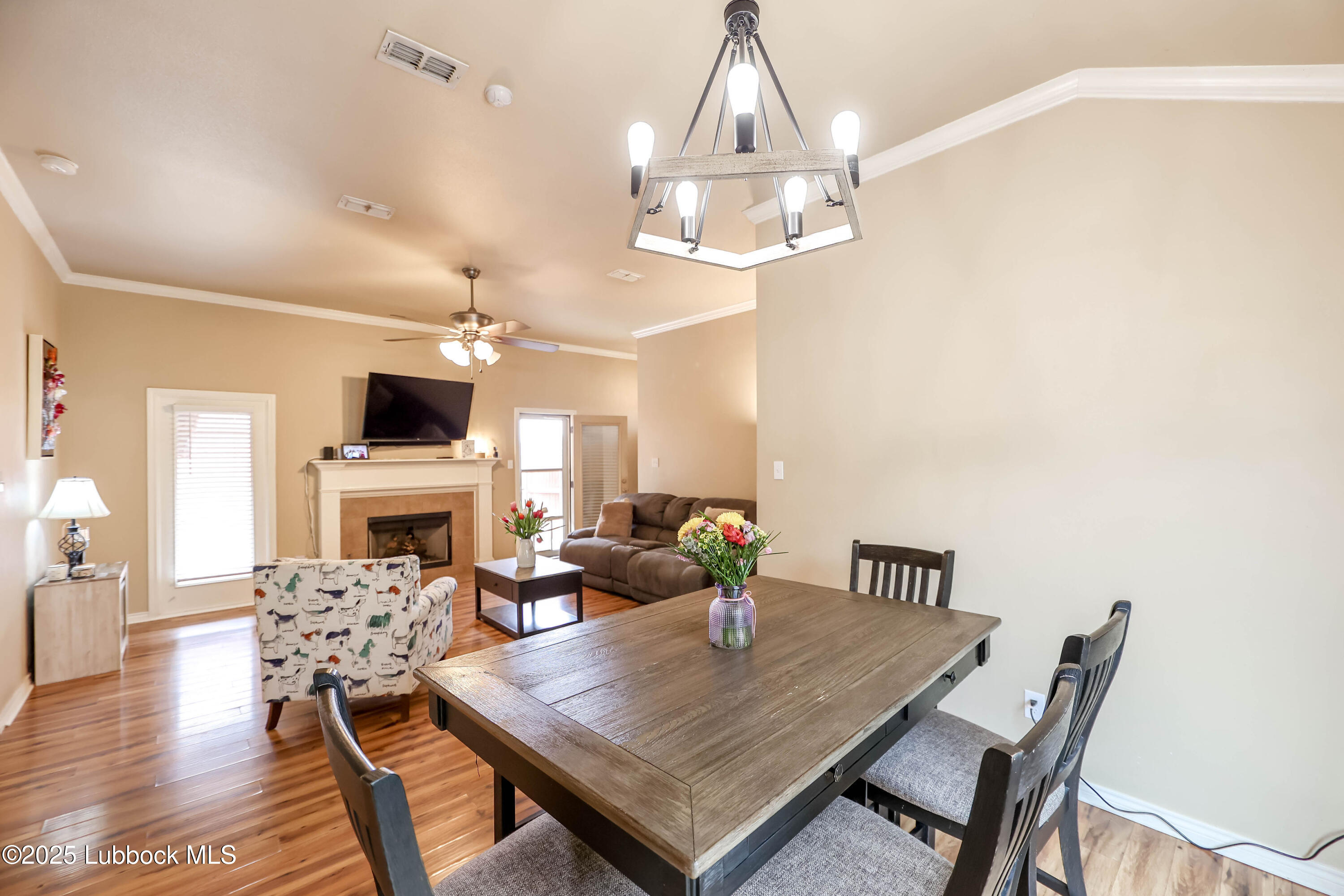 5920 104th Street Lubbock, TX 79424 - Photo 5 of 26 a view of a dining room with furniture a chandelier and wooden floor
