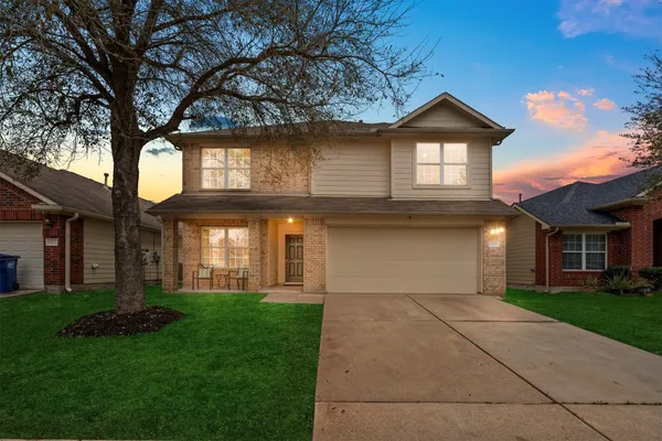 a front view of a house with a yard and garage