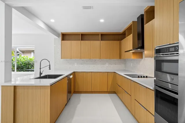 a kitchen with stainless steel appliances a sink a stove and a refrigerator