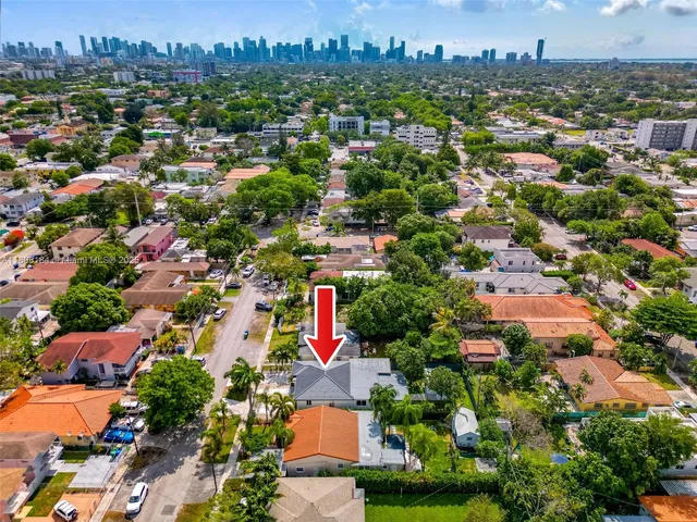 an aerial view of residential houses with outdoor space and trees