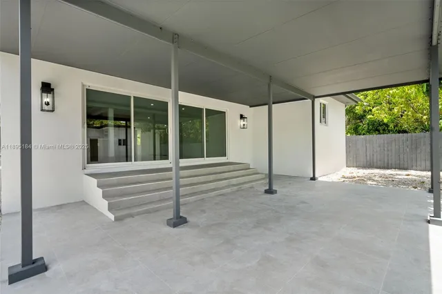 a view of an empty room with porch and patio