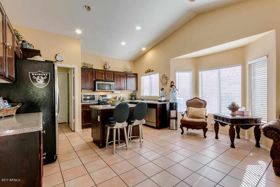 4030 West Cactus Road Phoenix, AZ 85029 - Photo 15 of 29 a open kitchen with granite countertop a sink cabinets and stainless steel appliances