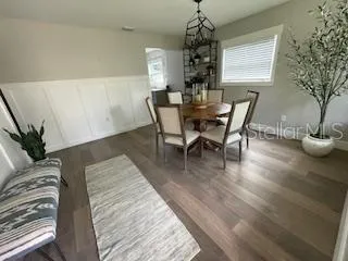 a dining room with furniture a chandelier and wooden floor