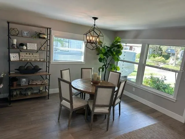 a dining room with furniture potted plants and wooden floor