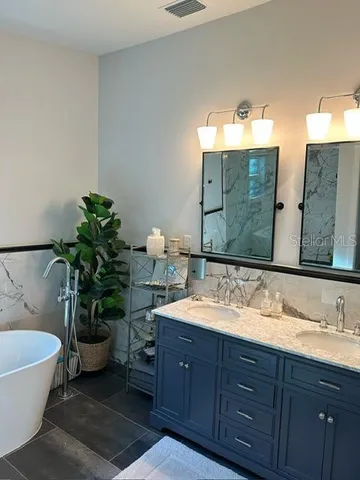 a bathroom with a tub sink and mirror