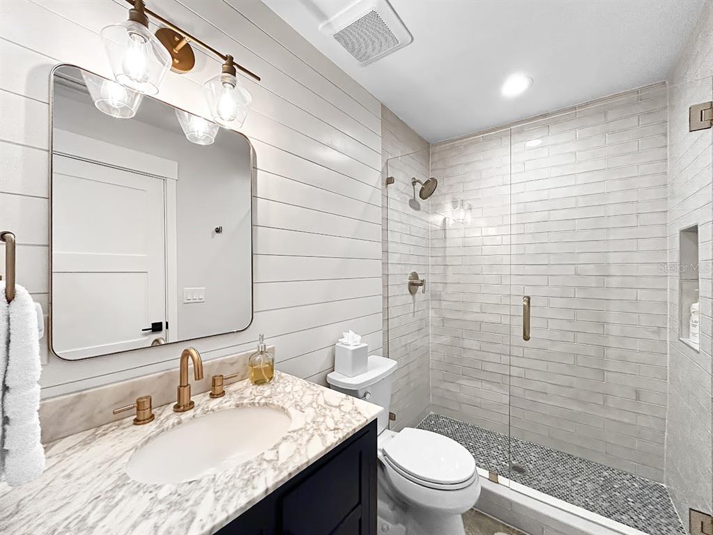 2908 West San Rafael Street Tampa, FL 33629 - Photo 23 of 27 a bathroom with a granite countertop sink a toilet a mirror and shower