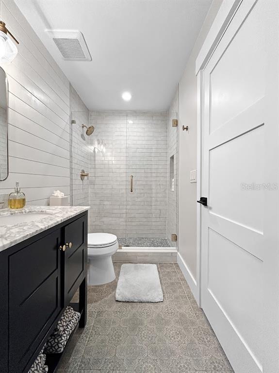 2908 West San Rafael Street Tampa, FL 33629 - Photo 24 of 27 a bathroom with a granite countertop sink a toilet a mirror and shower