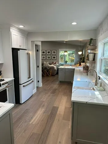 a living room with furniture and a refrigerator