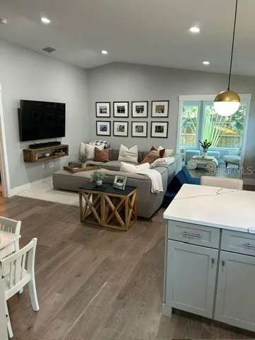 a living room with furniture a flat screen tv and a large window