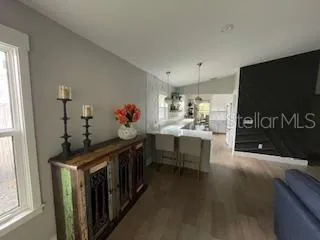 a kitchen with stainless steel appliances kitchen island granite countertop a table chairs in it and a window