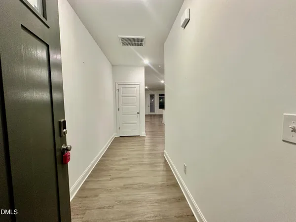 a view of a hallway with wooden floor