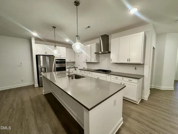 a kitchen with stainless steel appliances granite countertop a sink a stove and a refrigerator