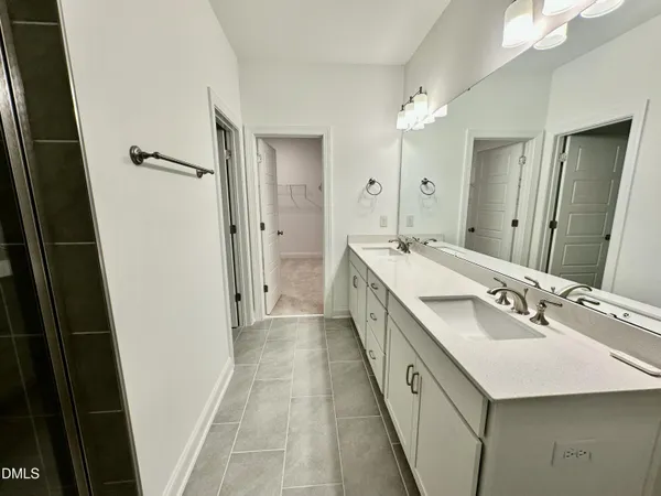 a bathroom with a double vanity sink and mirror