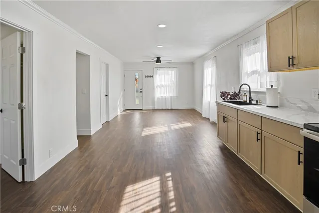 a kitchen with stainless steel appliances granite countertop a sink cabinets and wooden floor
