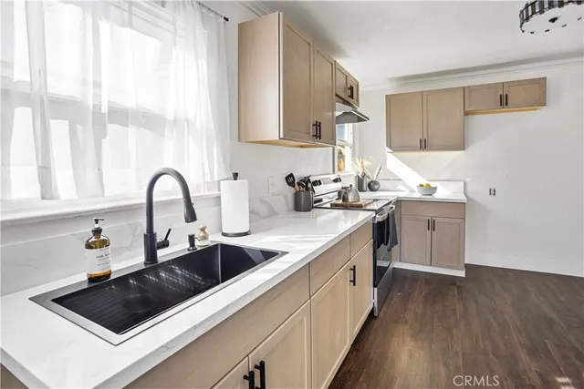 a kitchen with sink a stove and wooden floor