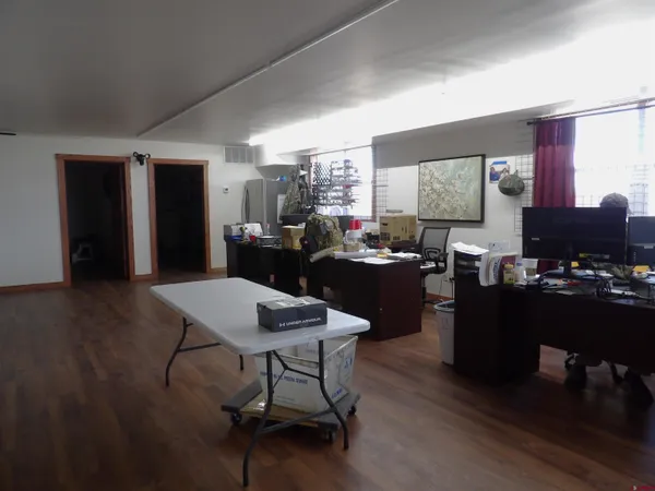 a living room with lots of furniture hard wood floor and a table