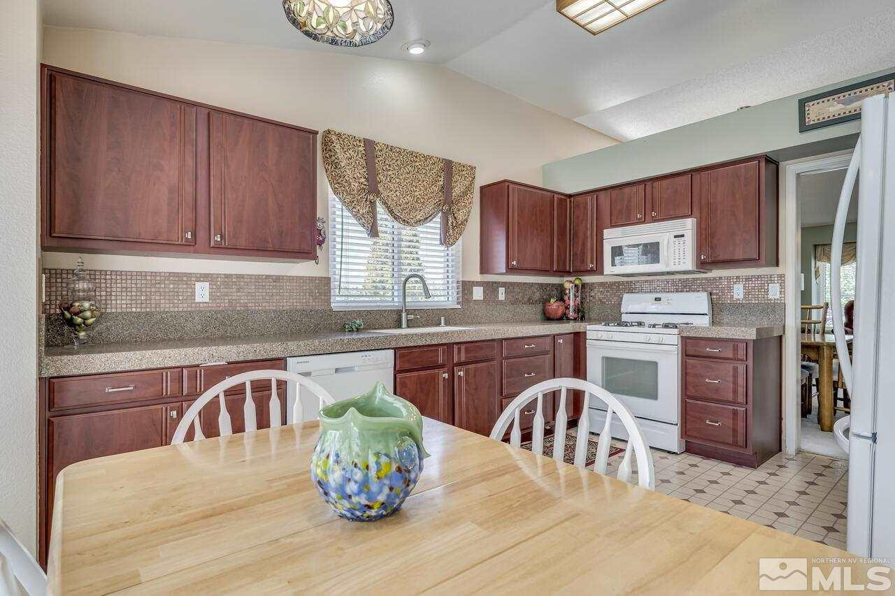5490 Simons Drive Reno, NV 89523 - Photo 14 of 37 a kitchen with stainless steel appliances granite countertop a stove top oven a sink dishwasher and cabinets with wooden floor