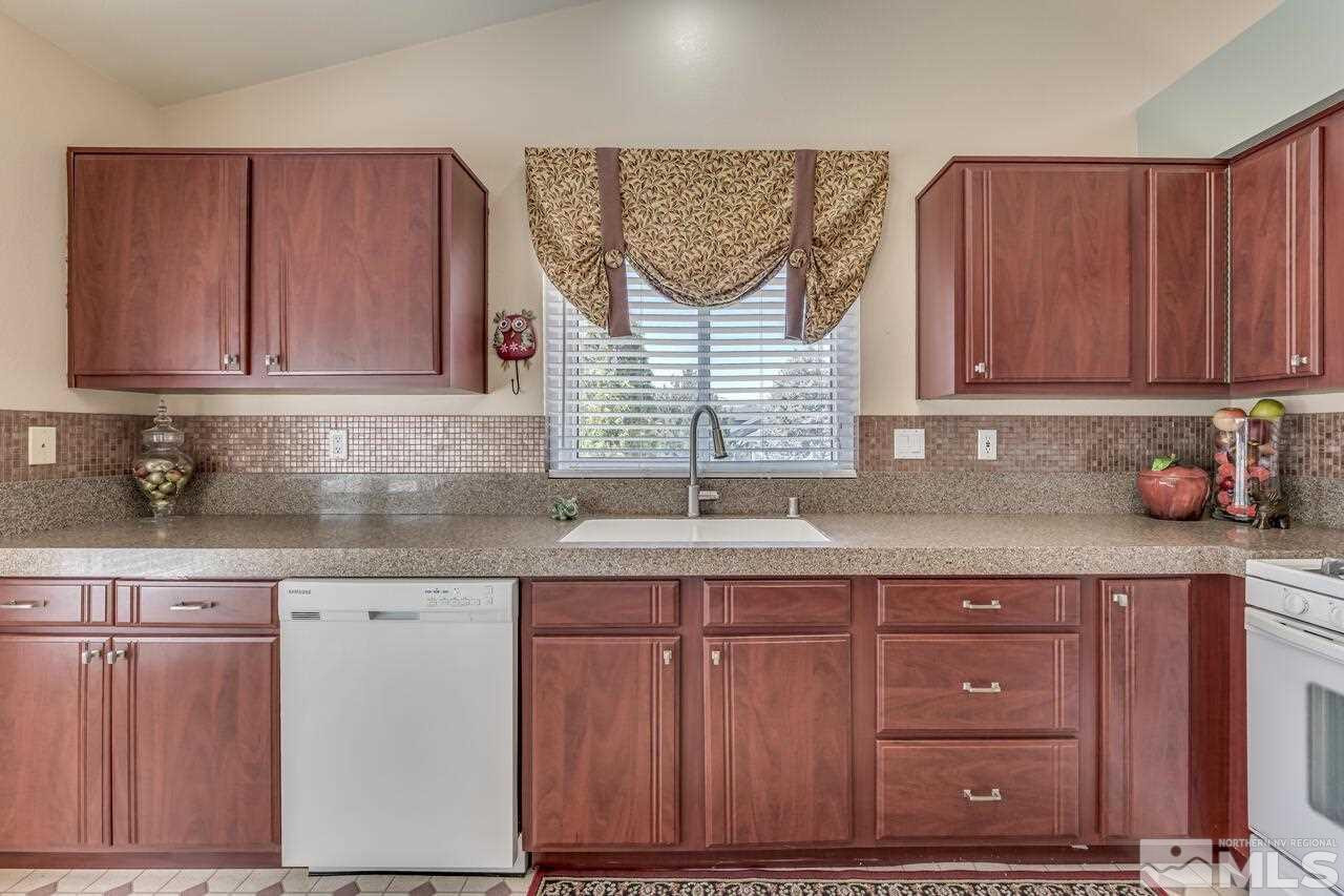 5490 Simons Drive Reno, NV 89523 - Photo 18 of 37 a kitchen with granite countertop wooden cabinets a sink and dishwasher