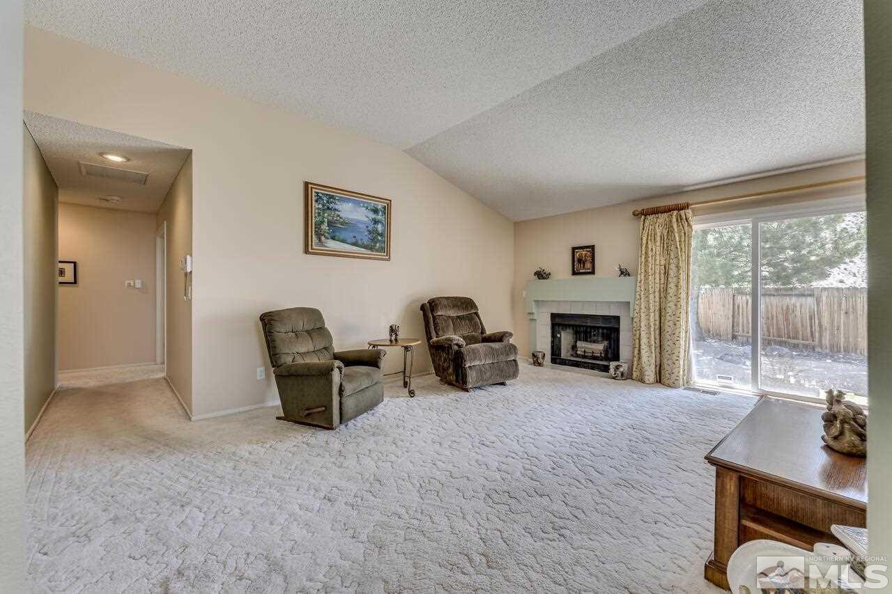 5490 Simons Drive Reno, NV 89523 - Photo 10 of 37 a living room with furniture a fireplace and a floor to ceiling window