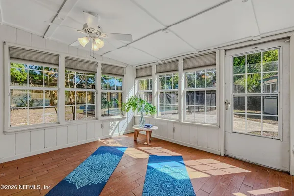 a living room with wooden floor and large windows