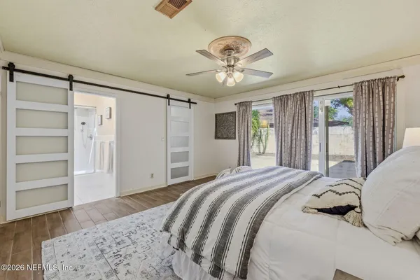 a bedroom with a large bed and a chandelier
