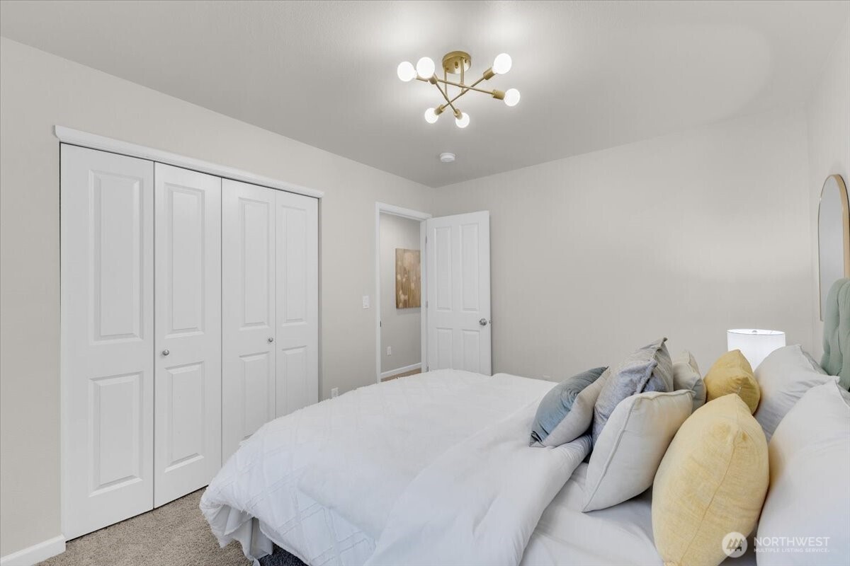 3532 202nd Pl S East Bothell, WA 98012 - Photo 25 of 39 a bedroom with a bed and a chandelier