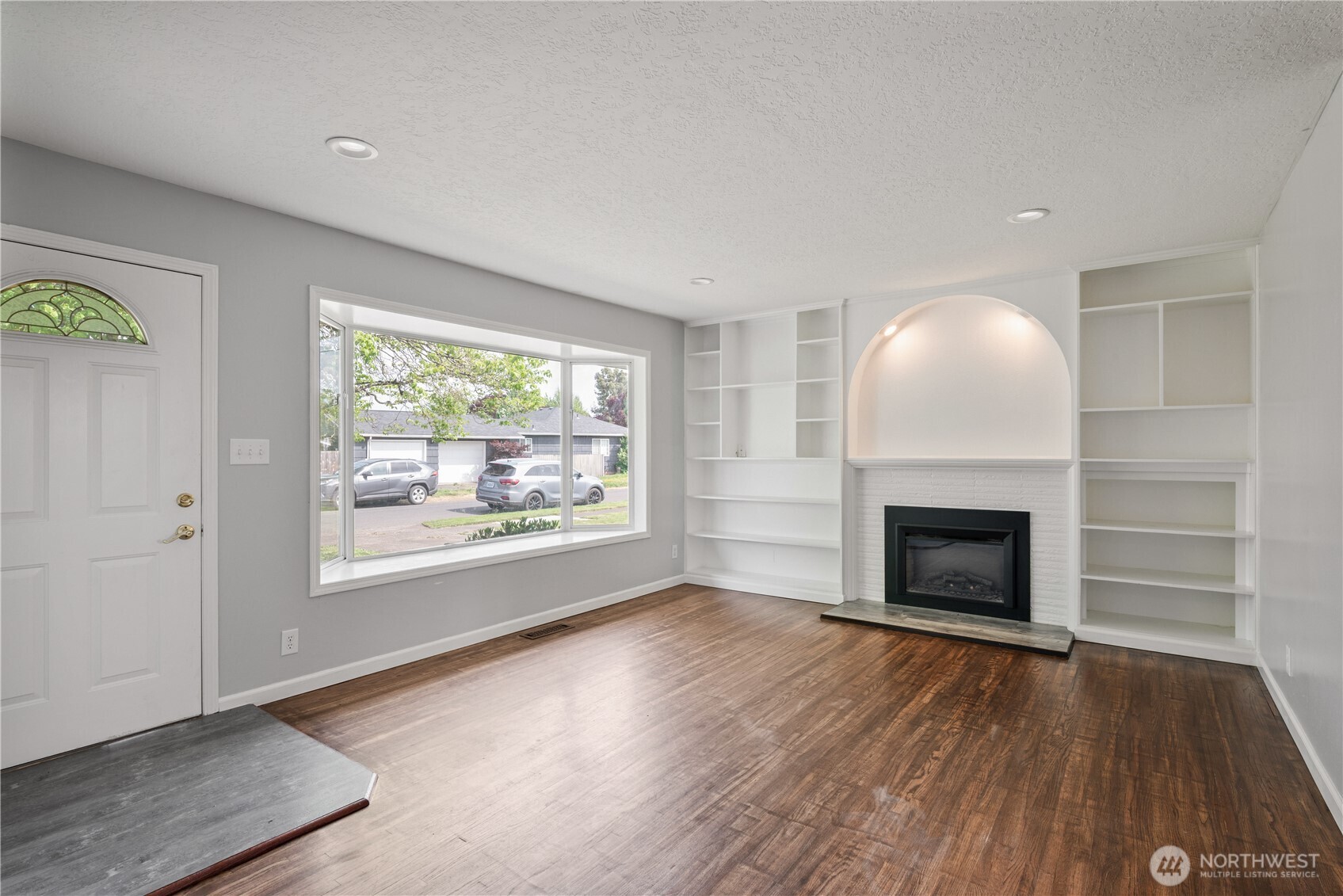 2017 28th Avenue Longview, WA 98632 - Photo 6 of 37 an empty room with windows a fireplace and wooden floor