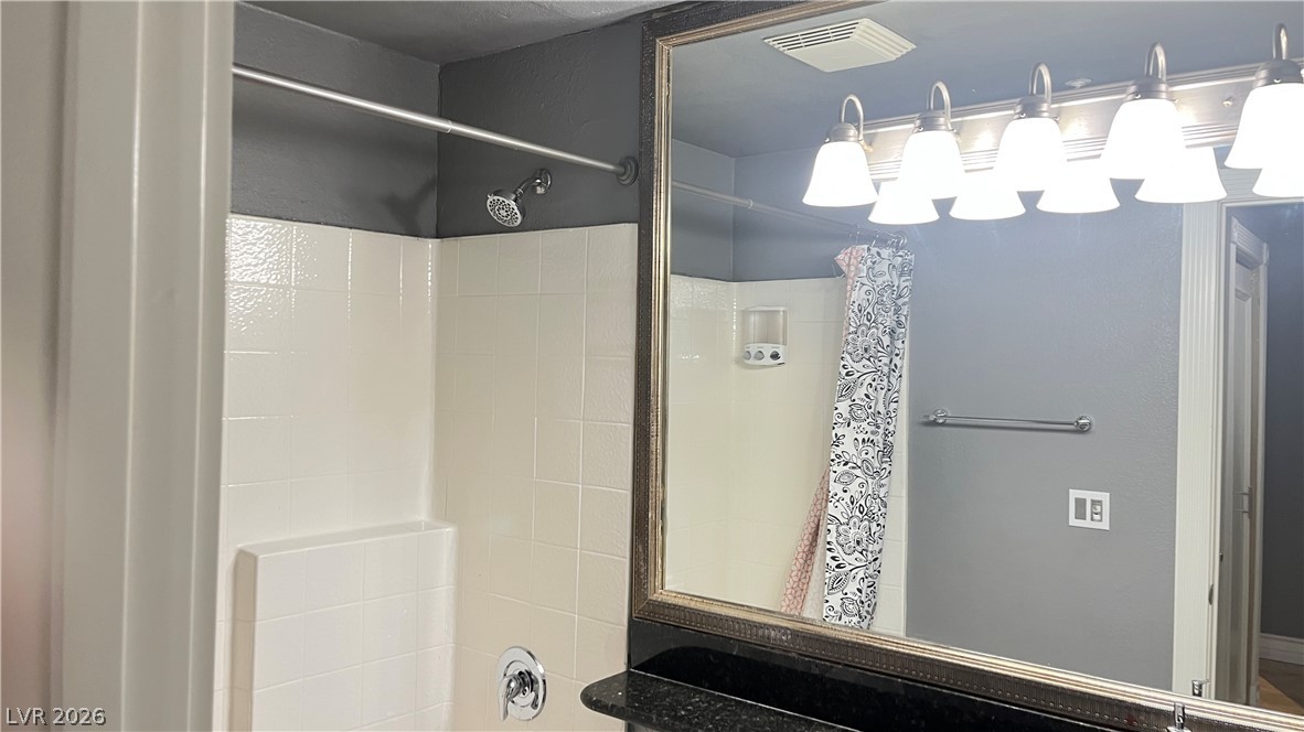 210 East Flamingo Road, Unit 205 Las Vegas, NV 89169 - Photo 12 of 17 A well-lit primary bathroom featuring a convenient shower with white tile surround.