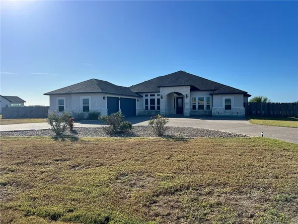 a large house with a big yard and large trees