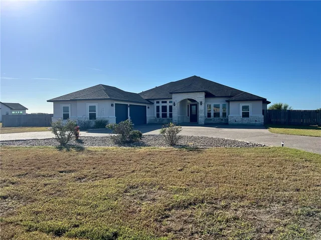 a large house with a big yard and large trees