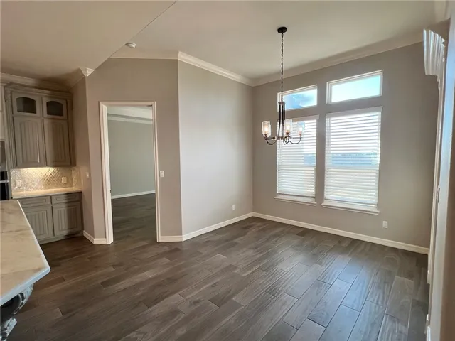 a view of a kitchen with wooden floor and a window