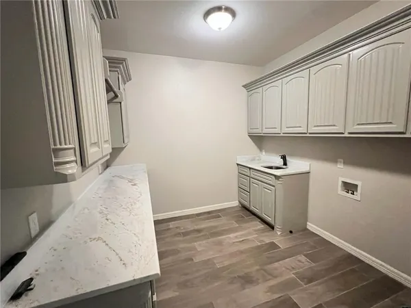 a utility room with granite countertop cabinets washer and dryer