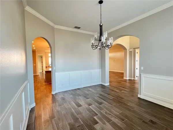 a view of a room with wooden floor staircase and a chandelier