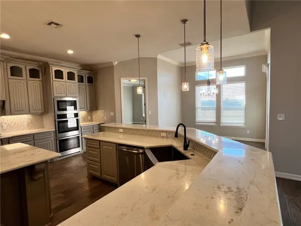 a kitchen with stainless steel appliances a sink stove and refrigerator