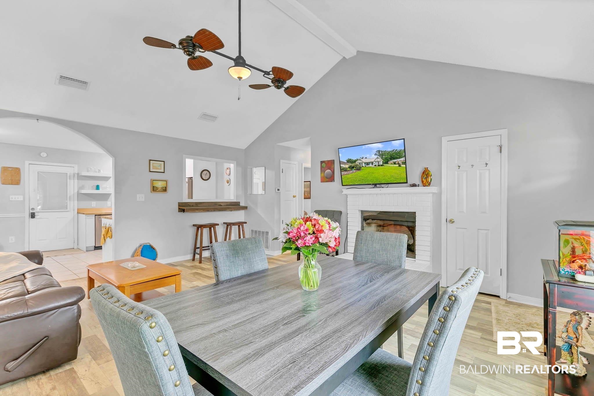 516 Juniper Place Drive Foley, AL 36535 - Photo 5 of 51 Dining space with a ceiling fan, high vaulted ceiling, beam ceiling, a brick fireplace, and light wood-type flooring