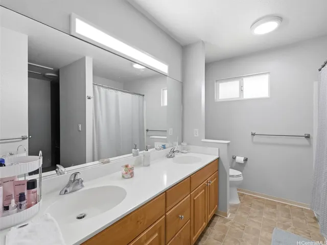 a bathroom with a double vanity sink toilet and mirror