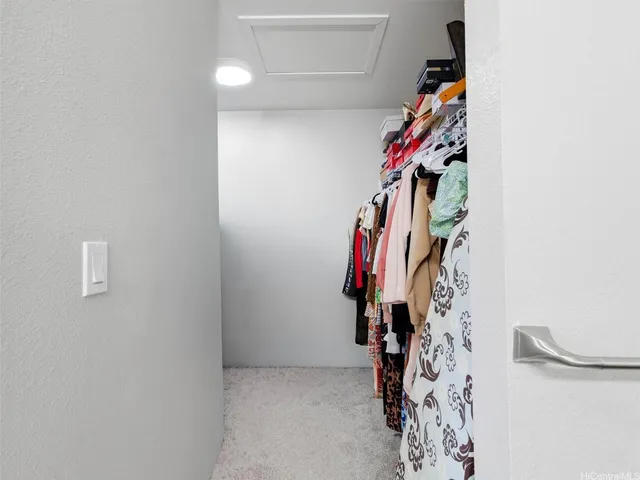 a view of walk in closet with clothes