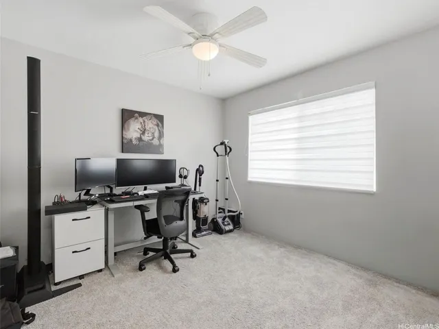 a view of a workspace with furniture and a window
