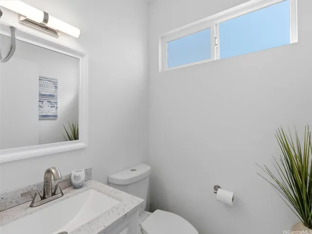 a bathroom with a sink a toilet and a mirror