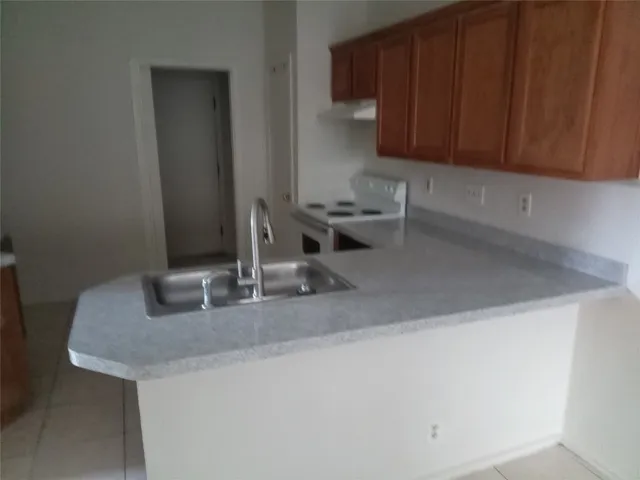 a kitchen with kitchen island a sink and wooden cabinets