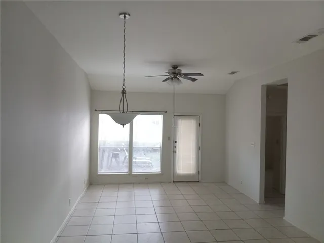 a view of an empty room with windows and cabinet
