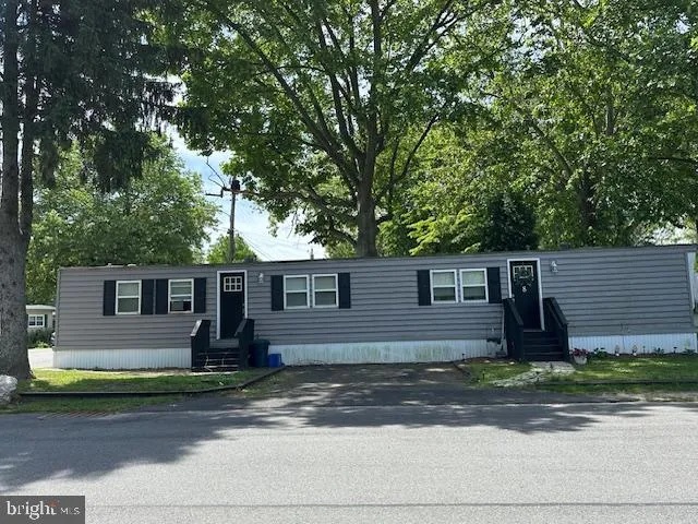 a front view of house with yard and tree in front of it