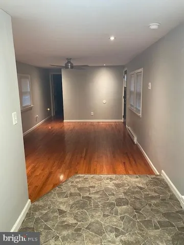 en empty room with wooden floor and windows