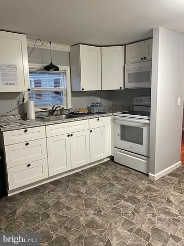 a kitchen with granite countertop a sink and cabinets