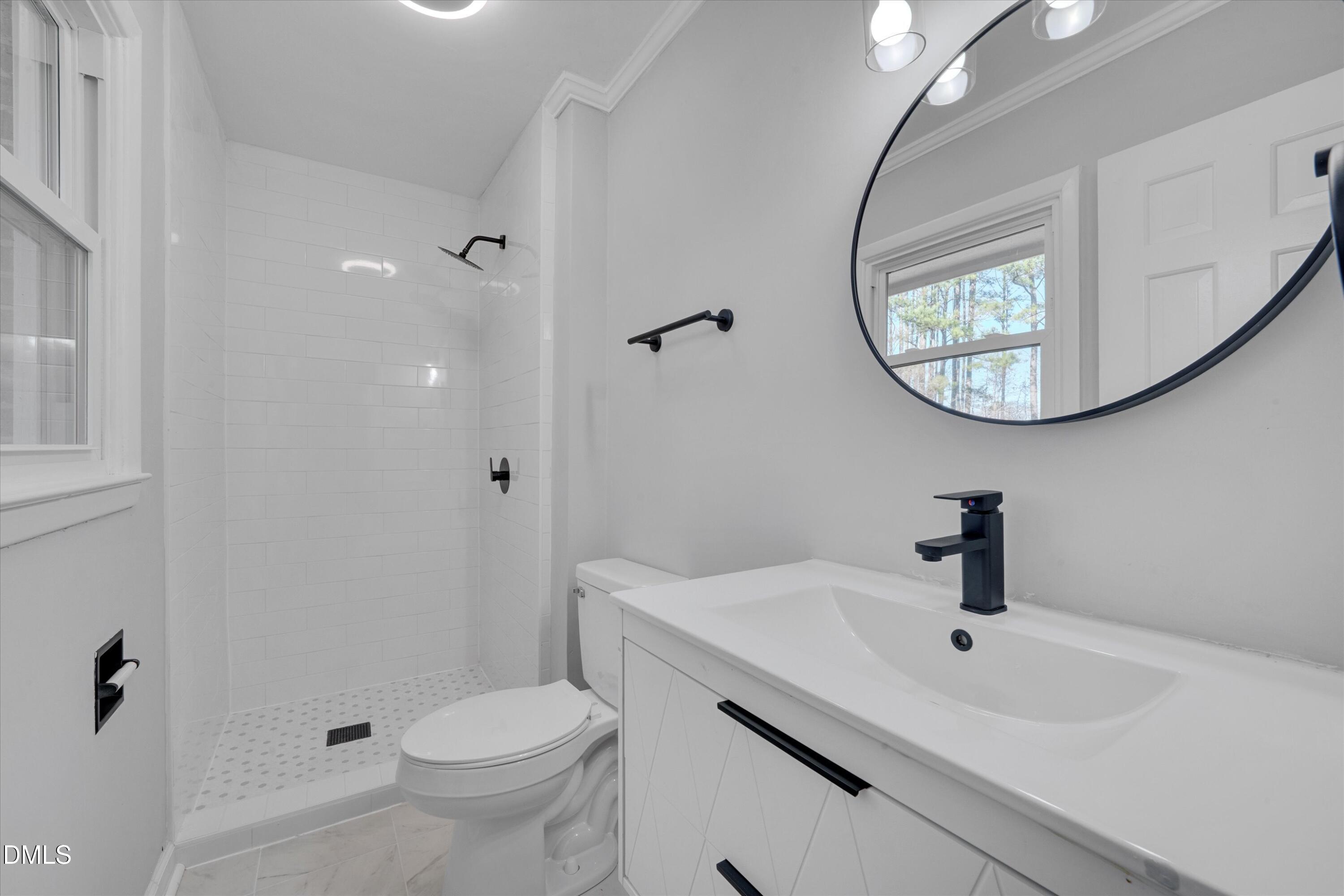 2728 South Cokesbury Road Henderson, NC 27537 - Photo 23 of 40 a bathroom with a sink and mirror with toilet